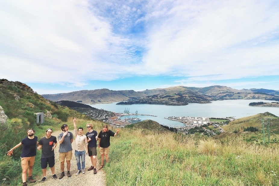 Group photo after hiking up the hills surrounding Lyttelton harbor. For those with keen eyes it is just possible to Spot the orange bow of the R/V Araon.