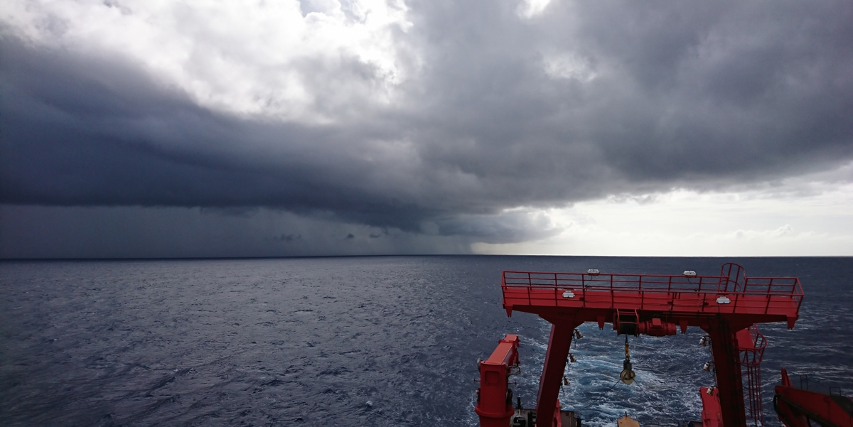 View across the aft of the German research vessel Meteor. At the horizon tropical rains wash down dust from the skies.