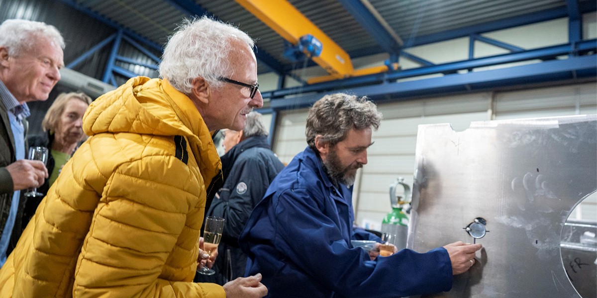 Henk van der Veer and Bram Fey inspect the coin, welded on the keel. Photo: Aernout Steegstra