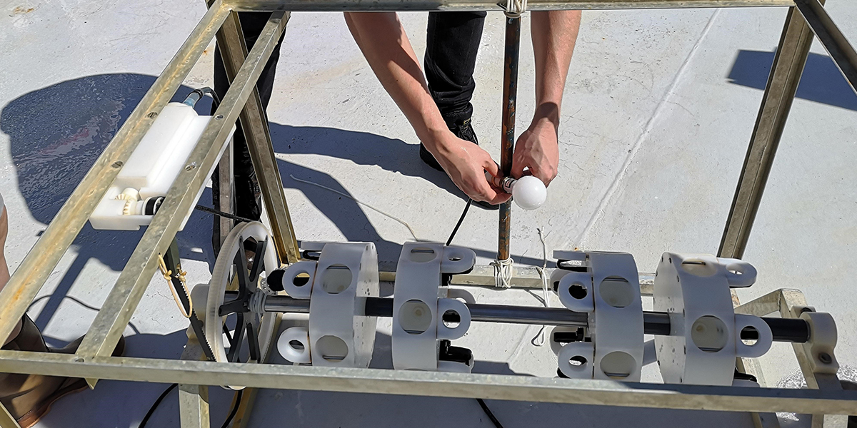 Fixing light meter on frame of incubator for testing irradiance level. Photo: NIOZ