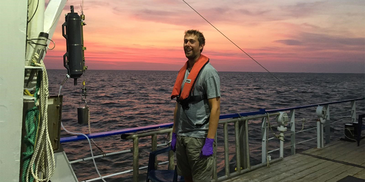 Pierre collecting seawater from the Niskin bottle at sunrise. Photo: NIOZ