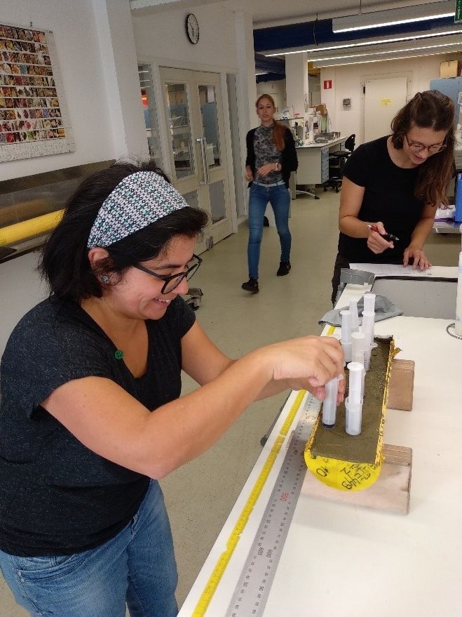 Back on Texel, the sections of the piston core are sampled: NIOZ researchers Zeynep, Kristin and Szabina are having the time of their lives. These samples also form the basis of the advertised projects (© Peter Kraal, NIOZ). 