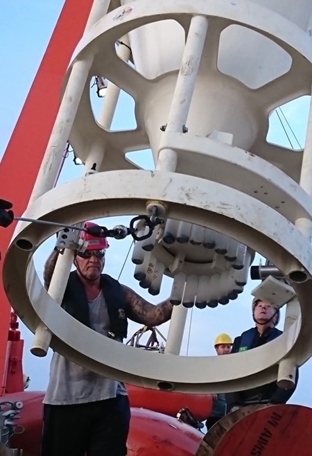 A sediment trap, nicely filled with sediments; in each cup you see some material. L2R: Pjotr, Jan-Dirk and Peter are putting the sediment trap in a safe place on deck where the eager scientists can harvest it.