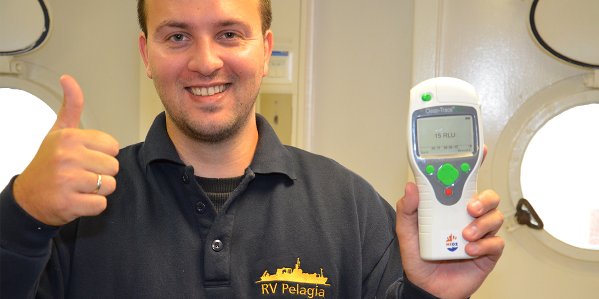 Cees van Slooten holding the luminometer showing a compliant ATP result