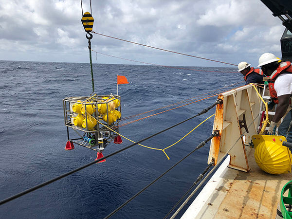 The deck crew of NOAA Ship Ronald H. Brown launches the NIOZ benthic lander for a long-term deployment on the seafloor near the coral mounds of Richardson Hills. Image courtesy of DEEP SEARCH 2019 - BOEM, USGS, NOAA