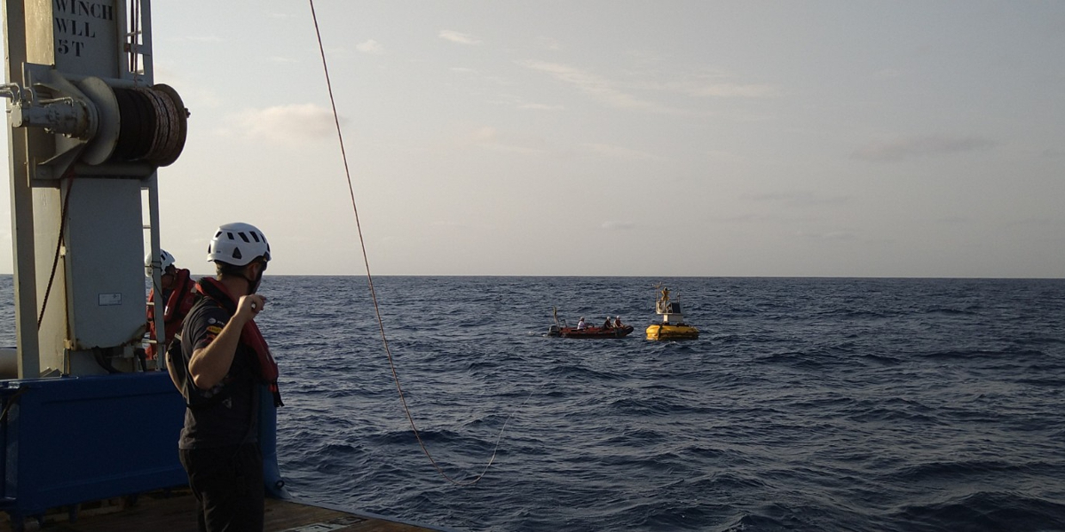 One of the dust buoys is about to be recovered from the NIOZ research vessel Pelagia. At the horizon there is a brownish haze, caused by Saharan dust.