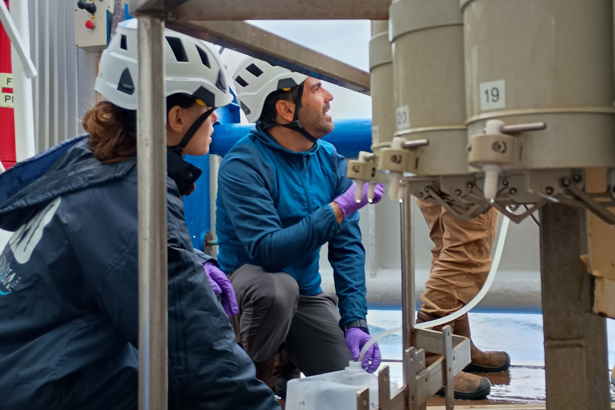 Miguel and Diana taking 5-L samples from the CTD for water filtration.