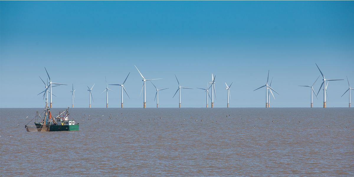 Visserboot en windmolenpark voor de kust van Engeland. Foto: ShaunWilkinson/Shutterstock.com 