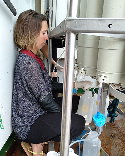 Close-quarters sampling. With millimeters to spare, Julie Lattaud makes sure the samples are taken immediately after the CTD/rosette is securely placed back on deck, ensuring the best results. Dedication.