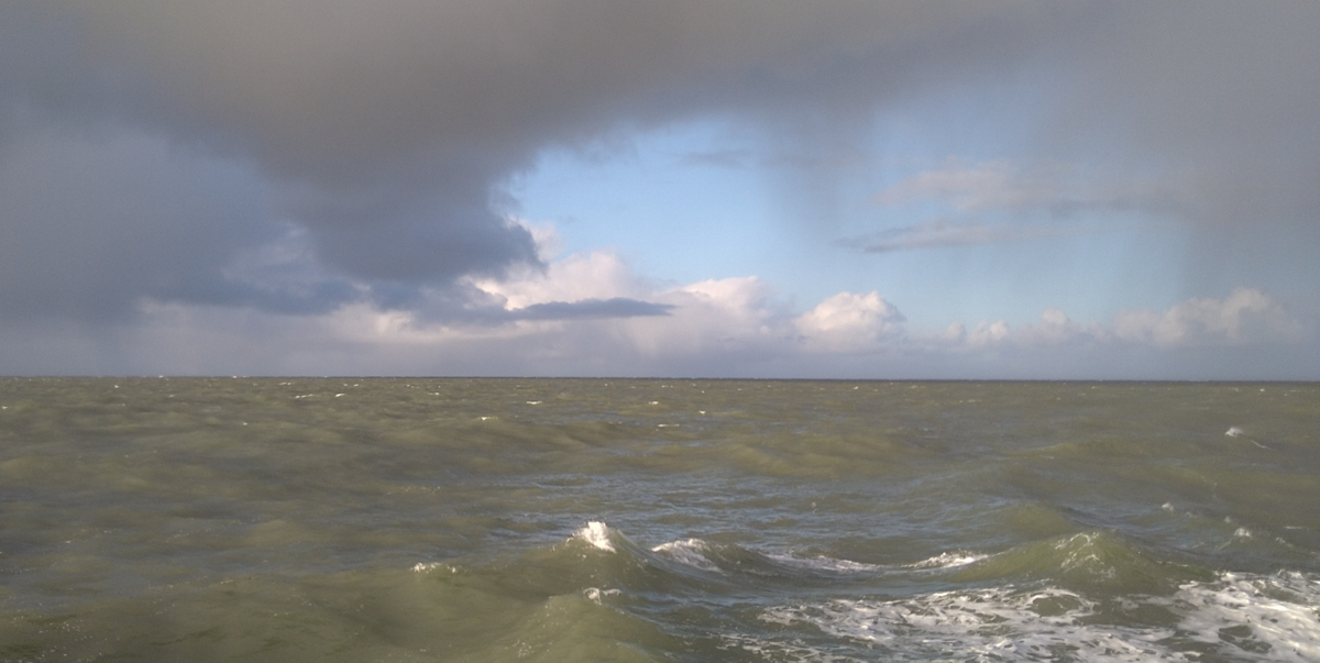 A typical Dutch seascape with clouds, blue skies and a green North Sea