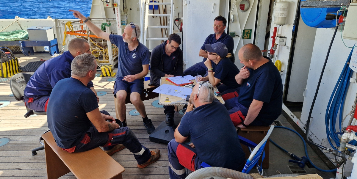 Toolbox meeting on deck in which Yvo explains the procedure of mooring recovery.