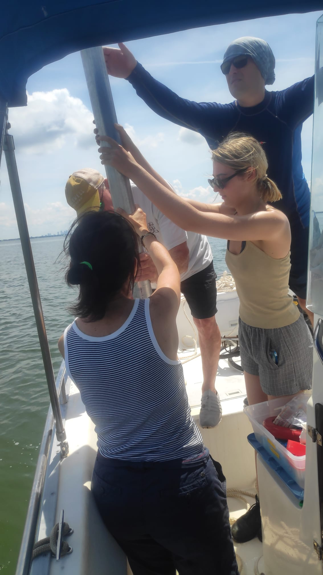 Dr. Francesca Sangiorgi, dr. Gregg Brooks, Suzanne de Zwaan and dr. Patrick Schwing retrieving the sediment core from the water in Tampa Bay