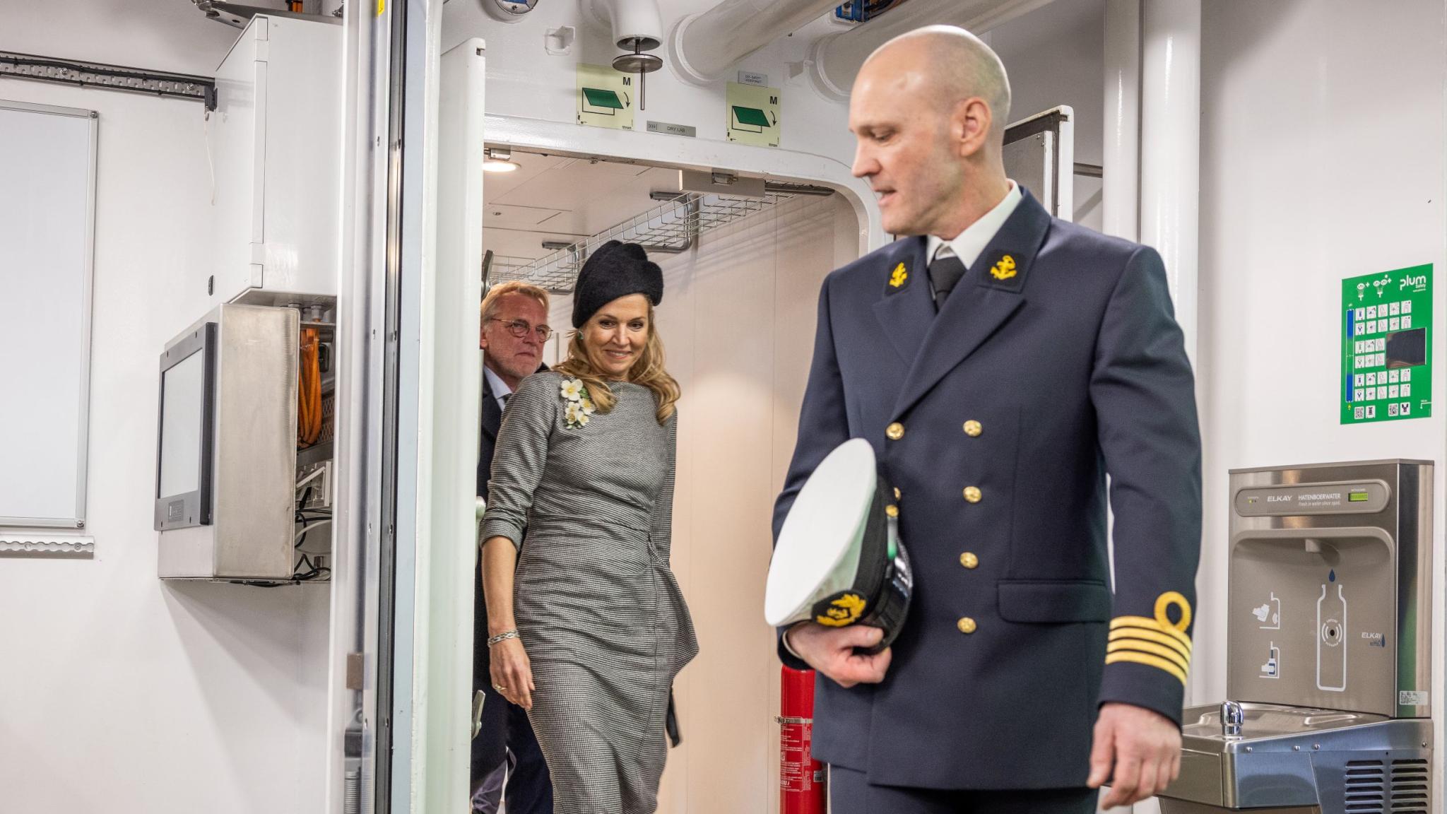 De kapiteitn passeert een deur, gevolgd door de koningin en de NIOZ-directeur
