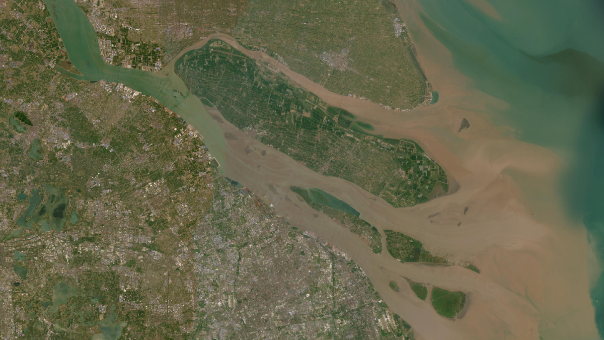 Satellite image of a river delta with branching waterways, islands, and surrounding landscape.
