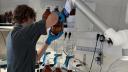 Een onderzoeker die in een laboratorium zeewatermonsters filtert met behulp van glazen filterapparatuur en bruine monsterflesjes.
