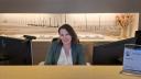 Picture of Claudia Prins, receptionist at NIOZ, sitting behind a desk.