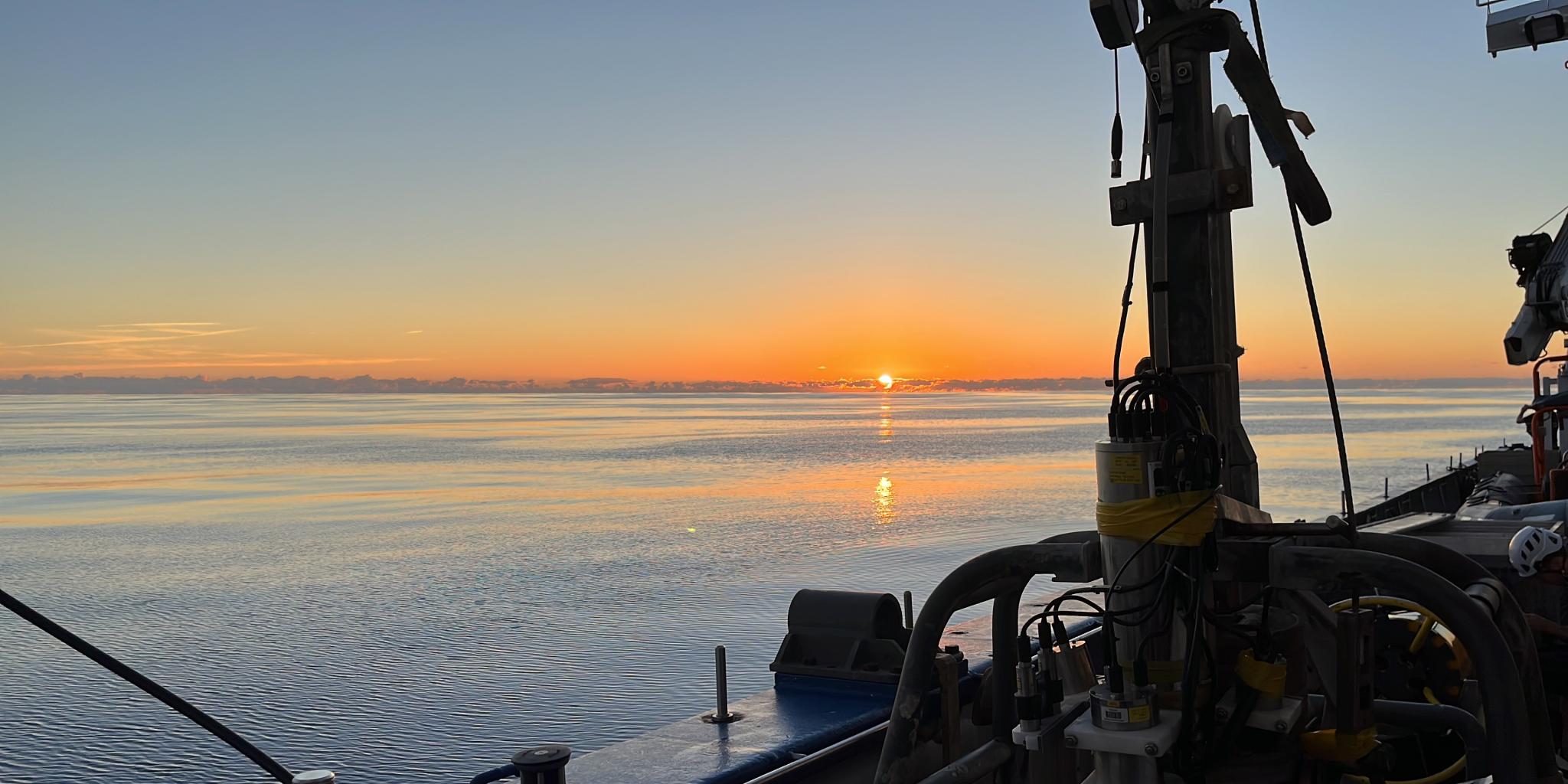 Sun setting in the water seen from the ship (RV Pelagia)