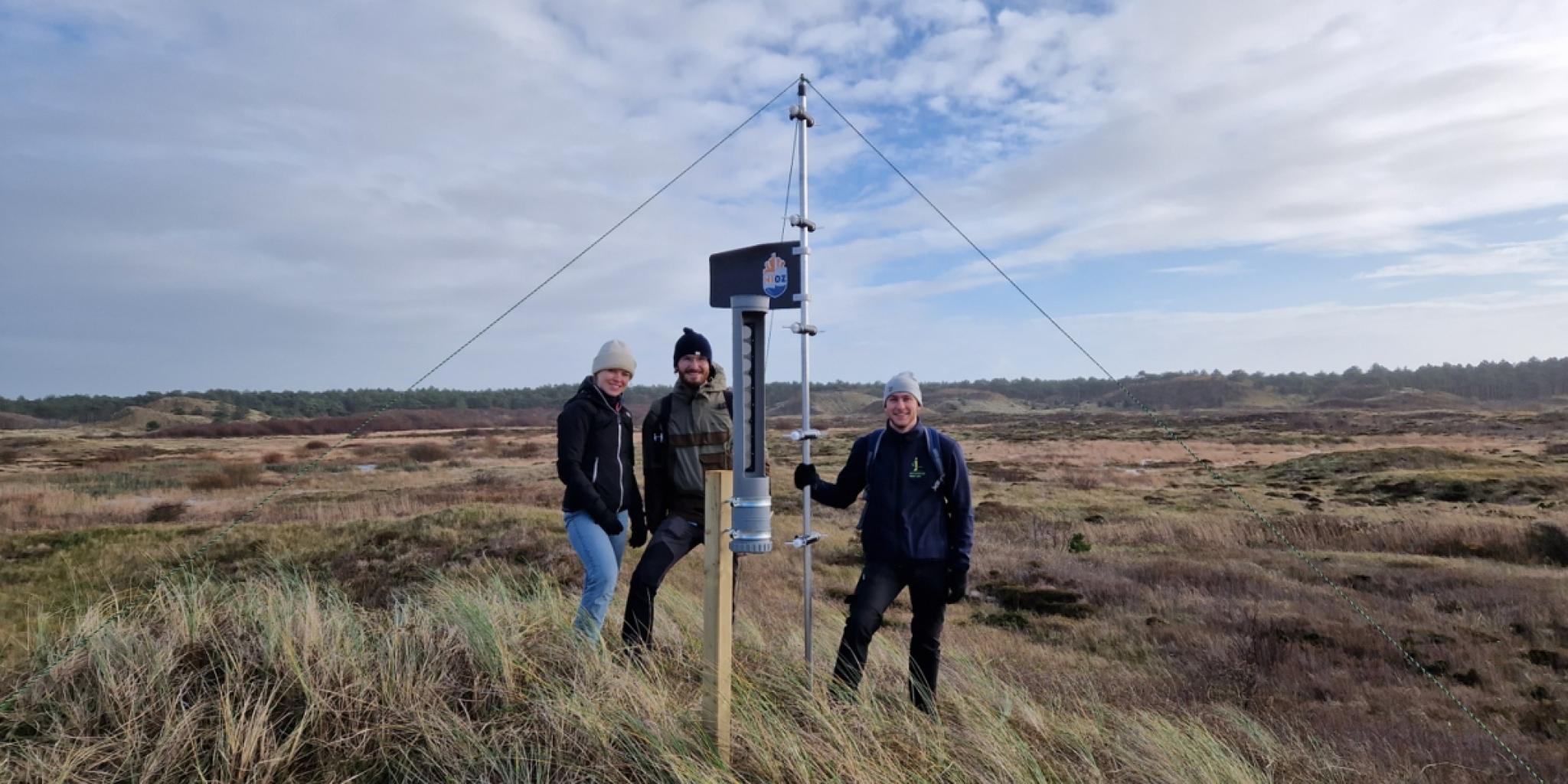 Drie mensen en het gereedschap dat zand vangt