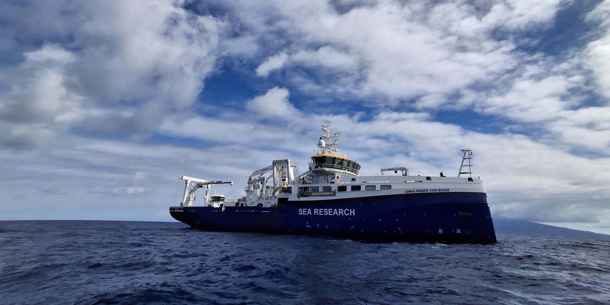 view of blue research vessel, seen from just above the sea level