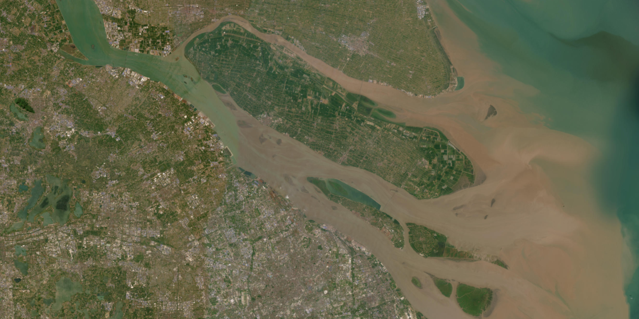 Satellite image of a river delta with branching waterways, islands, and surrounding landscape.