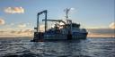 Het schip RV Wim Wolff, gezien tijdens een vaart op een kalme zee, vlak voor zonsondergang.