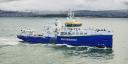Blue research vessel sails along the coast of Spain