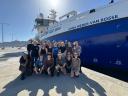 Group of people on the quay of Mindelo with reseach vessel in background