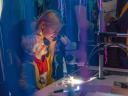 Woman and boy watch through a microscope in purple deepsea setting