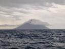 De typische vulkaanvorm van de Stromboli die uit de Tyrrheense Zee steekt.