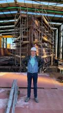 Gert-Jan Reichart posing before the ship under construction