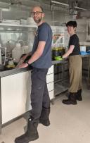 Two people filtering seawater samples on board.