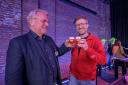 Two men holding a tasting glass of beer