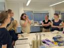 A group of students discusses the analysis of water samples while one student uses a refractometer in the laboratory.