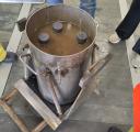 Top-down view of three sediment sample jars in a metal container filled with brown water, surrounded by researchers.
