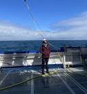 Annalisa stands with her face turned towards the sun on the deck of the research vessel between manta net deployments.