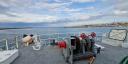 Sailing out of the harbour, with the stone harbour head on the right and in the front the winch on the front deck